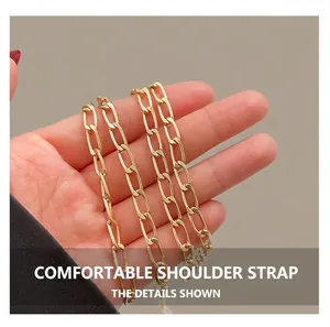 Polished gold-tone oval metal chain strap detail on a stylish shell-shaped crossbody bag