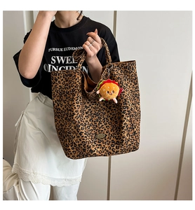 Dettaglio della borsa tote in tela leopardata con un creativo ciondolo a forma di hamburger
