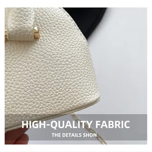 Macro view of white lychee pattern leather handbag with gold metal hardware and chain