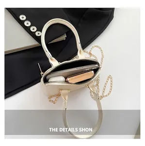 Interior view of minimalist crossbody bag holding phone and earbuds with gold chain