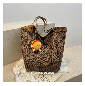 Dettaglio della borsa tote in tela leopardata con un simpatico ciondolo a forma di burger