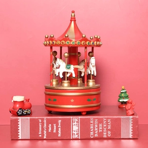 Christmas carousel music box in red and gold with four white horses on a red book