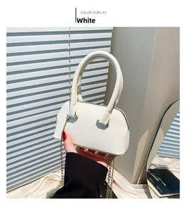 Close-up of white lychee pattern leather shell bag with elegant gold chain strap
