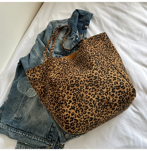 Vista piatta di una borsa tote leopardata in tela su una giacca di jeans con luce naturale