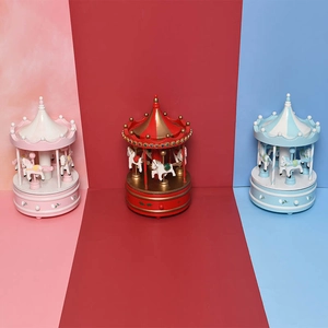Three colorful carousel music boxes in pink, red, and blue with hand-painted details
