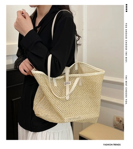 Detail of hollow straw weave pattern and white leather strap on a beige tote bag