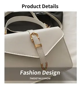 Detail of minimalist white leather crossbody bag with polished gold metallic pin buckle