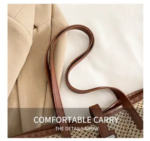 Detail of woven straw tote bag with brown faux leather handles and fine stitching