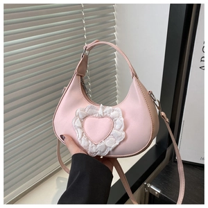 Close-up of light pink hobo bag featuring a heart-shaped lace patch and chain detail