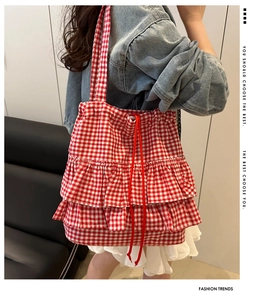Detail of red gingham tote bag with stylish ruffled edge and chiffon trim detailing