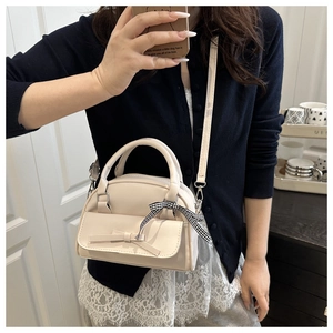 Cream square bag with ribbon and bow details shown in a lifestyle mirror selfie