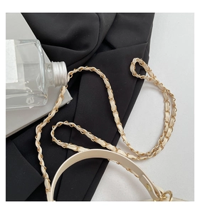 Detail of premium beige box bag with gold-tone metal chain strap and leather stitching