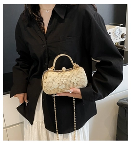Détail du sac de soirée en dentelle dorée avec fermoir en strass et bandoulière chaîne