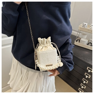 Detailed view of white crocodile texture box bag with pearl handle and chain strap