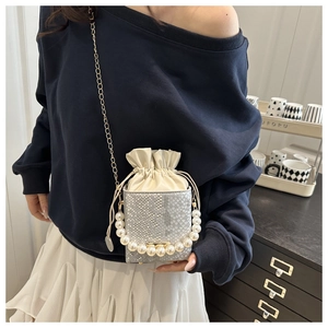 Detail of silver snake-pattern bucket bag with pearl handle and drawstring closure