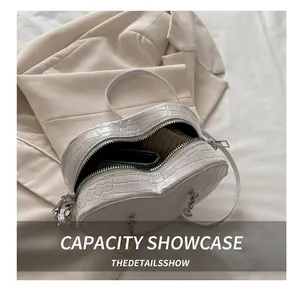 Capacity display of white heart-shaped bag featuring faux crocodile pattern and zipper closure