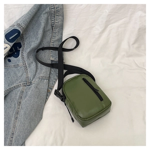 Detail of olive green tactical crossbody bag with double zippers and black nylon strap