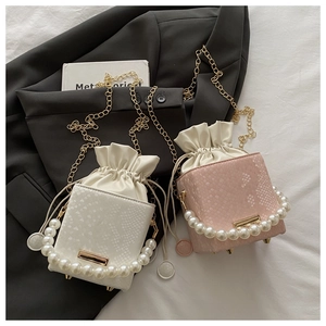 Detail of snake embossed leather bucket bags with pearl handles and gold chain straps