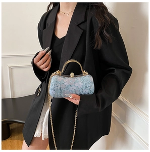 Vue détaillée du sac de soirée bleu clair en dentelle avec strass et anse dorée