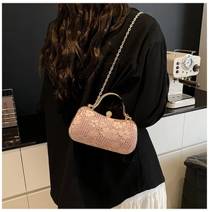Détail du sac de soirée à paillettes roses avec motifs dentelle et anse dorée