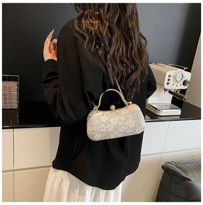 Sac de soirée en dentelle avec chaîne dorée présenté dans un cadre chic et moderne