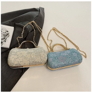 Détail de pochette en dentelle à paillettes avec poignée métal et chaîne dorée