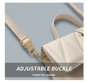 Détail du sac en cuir matelassé blanc montrant la boucle réglable dorée et le mousqueton
