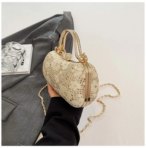 Détail du sac de soirée champagne doré avec dentelle florale et poignée en métal sertie