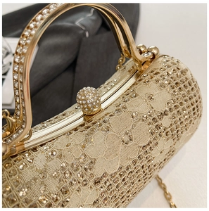 Détail du tissu en dentelle à paillettes dorées et du fermoir boule serti de diamants