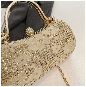 Détail d'un sac de soirée à paillettes dorées avec fermoir en strass et chaîne