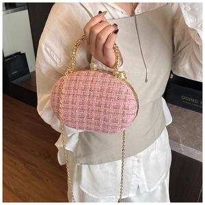 Detail of pink tweed evening bag with gold metal handle and sparkling crystal clasp