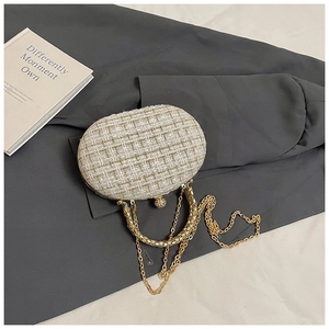Detail of elegant beige tweed evening clutch with diamond-encrusted spherical metal clasp