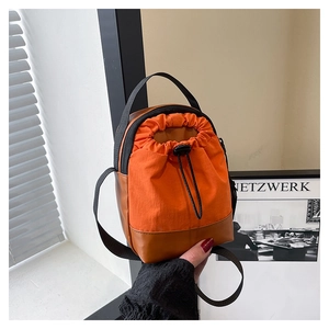 Detail of the orange nylon and brown leather small crossbody bag with drawstring