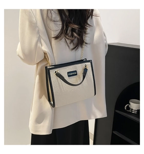 Détail de la texture tissée et du lettrage de mode sur le sac à bandoulière contrasté