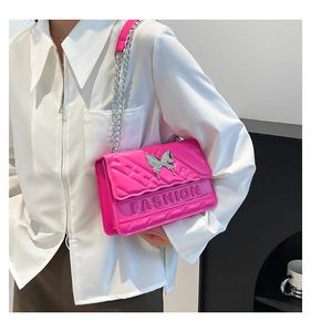 Detail of fuchsia quilted handbag with silver butterfly buckle and FASHION lettering