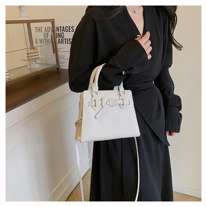Détail d'un sac à main blanc avec décoration nœud élégante et fermoir en métal doré