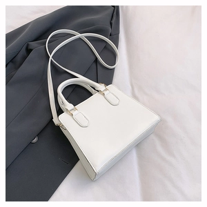 Gros plan détaillé du sac cabas blanc en cuir PU avec boucle métallique dorée