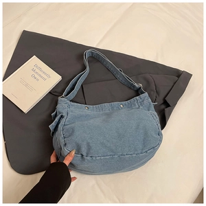 Détail du sac hobo en denim bleu vintage avec bandoulière réglable et rivets