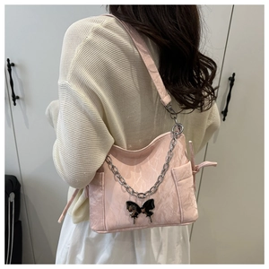 Detail of pink shoulder bag featuring pleated texture and black metal butterfly buckle