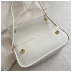 Detailansicht der weißen Ledertasche mit goldenen Magnetverschlüssen und Innenfutter