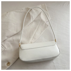 Detailed top view of a white matte PU leather underarm bag on soft corduroy fabric