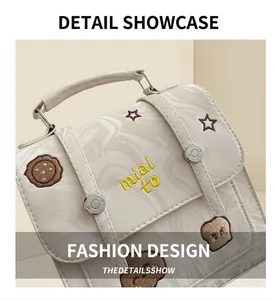 Detail of cream marble texture handbag featuring star embroidery and metal buckles