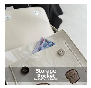 Detail of minimalist cream bag featuring magnetic closure and marble pattern front pocket