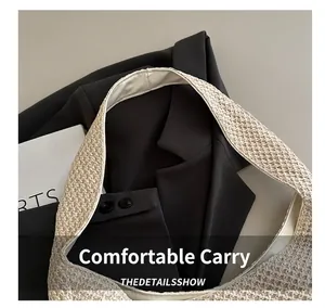 Detailed close-up of wide woven handles on a beige straw vacation tote bag for women