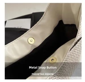 Close-up of golden magnetic snap and cream leather trim on woven straw tote bag