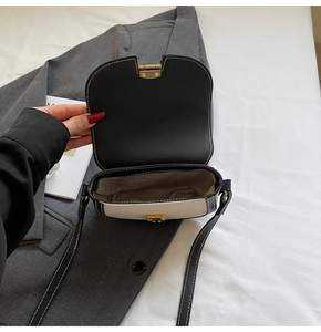 Vue intérieure du sac bandoulière bicolore montrant la doublure et les détails dorés