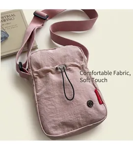 Close-up of pink nylon crossbody bag with ruffled texture and drawstring pocket detail