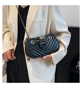 Vue détaillée de la texture en cuir matelassé et de la boucle noire sur ce sac moderne