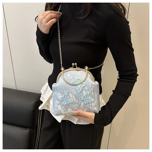 Detail of light blue satin embroidery bag featuring 3D butterfly appliques and round handle