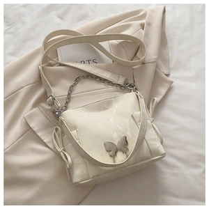Detail of cream crossbody bag with silver butterfly buckle and marble texture PU leather